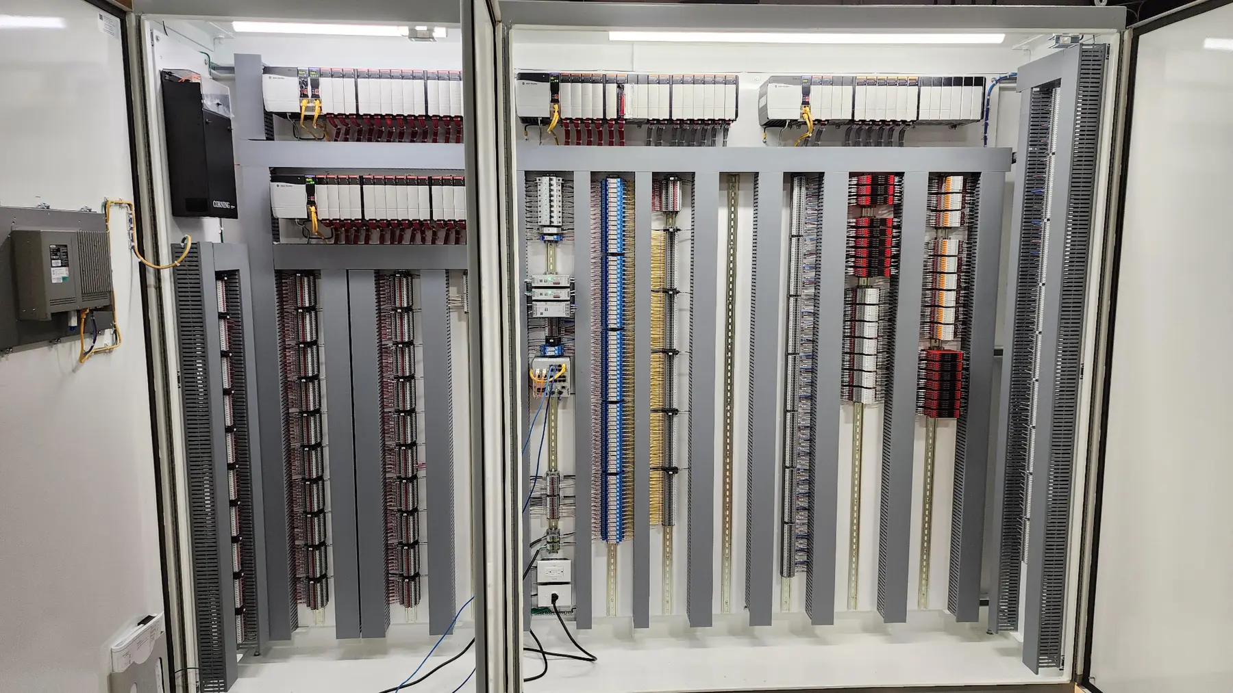 Open industrial control panels with PLC hardware and field wiring