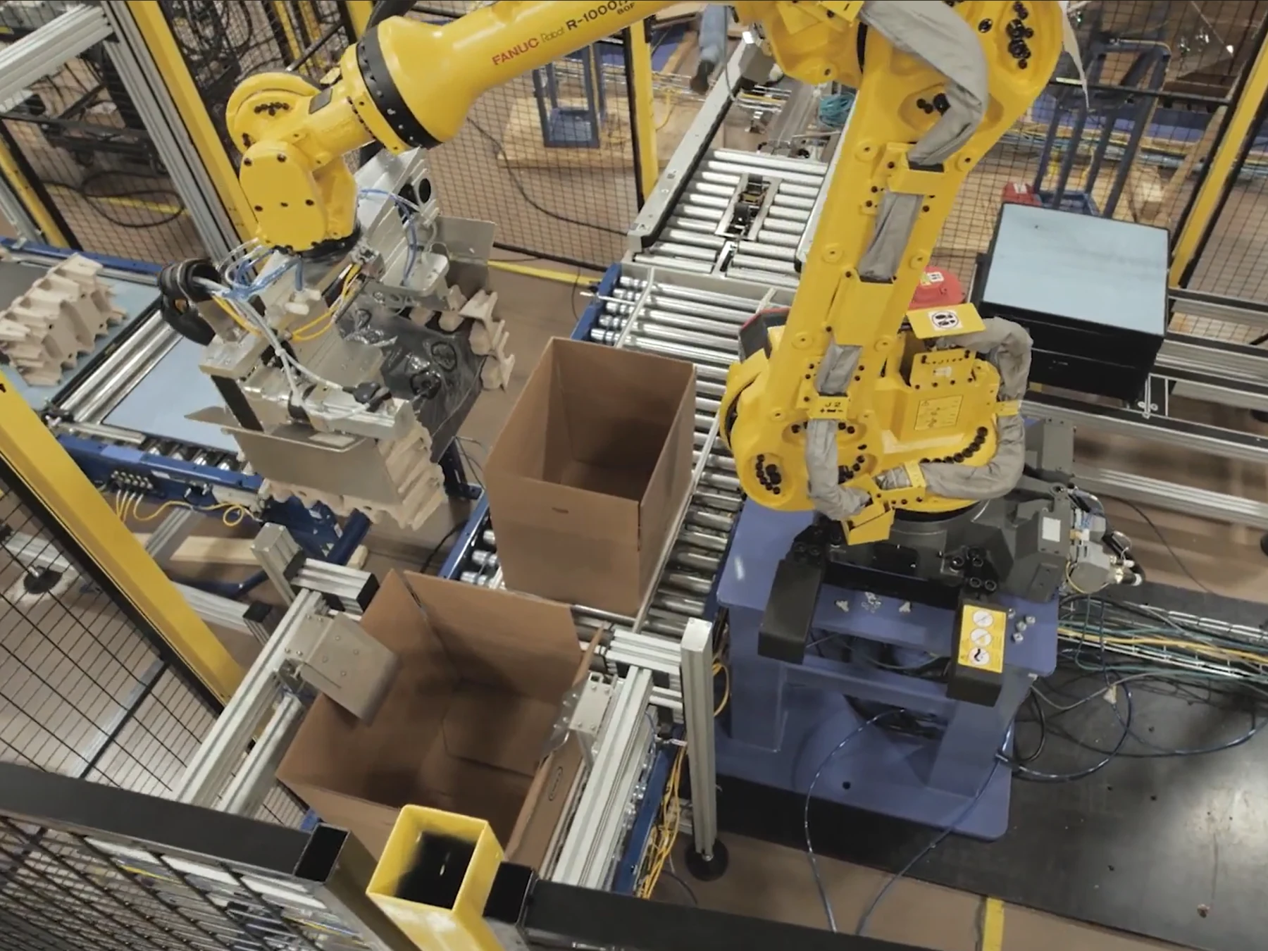 Automated material handling system with multiple industrial robots and conveyors